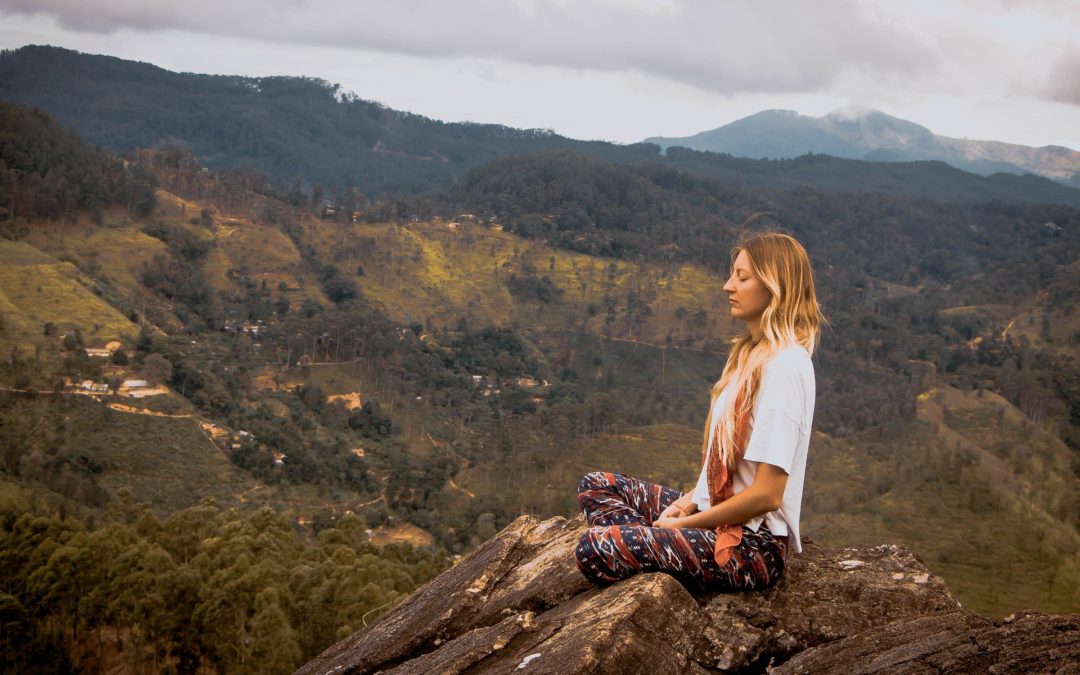 women meditating on a mountain