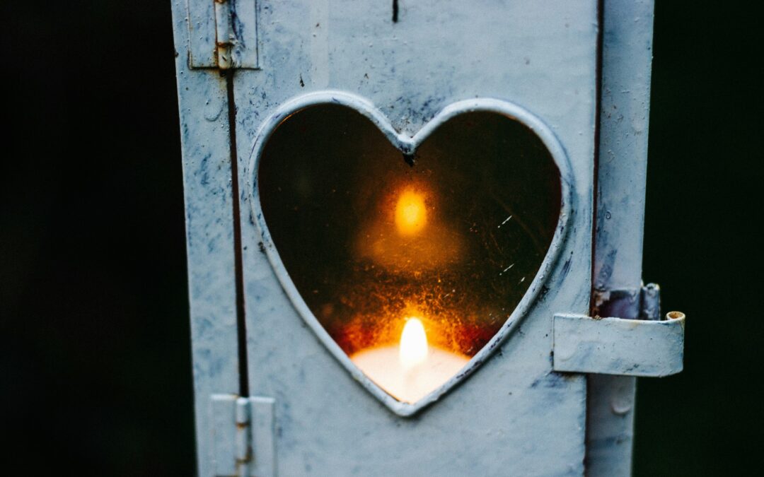 lit candle shows through heart-shaped window